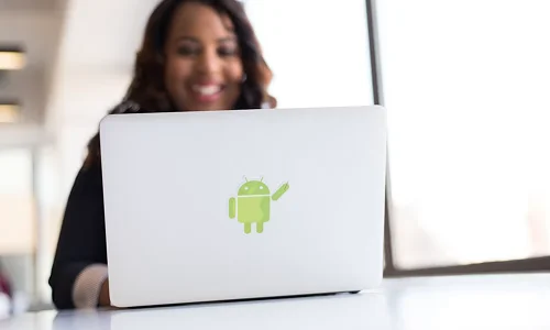 Developer working on a laptop with an Android logo