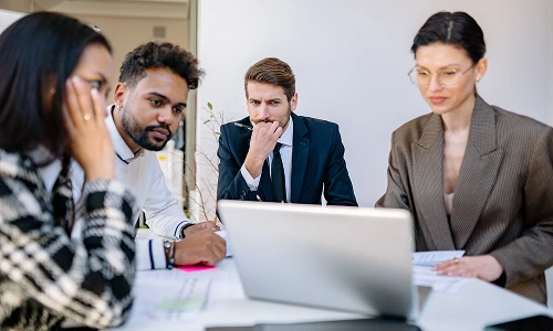 Consultants discussing an app project around a laptop