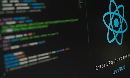 React logo beside application source code on a computer screen